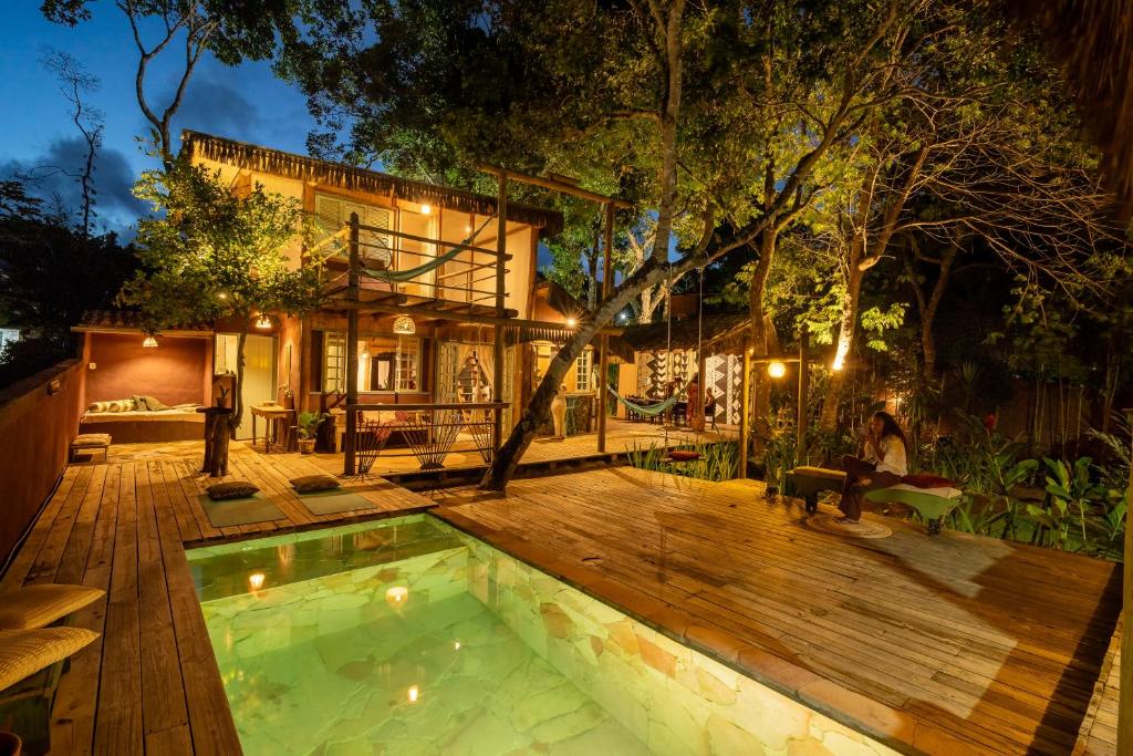 a backyard with a swimming pool and a house at Villa Bakari in Arraial d'Ajuda