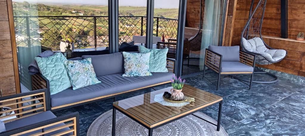 a couch on a porch with a table and chairs at Vikendica Vista in Vrdnik