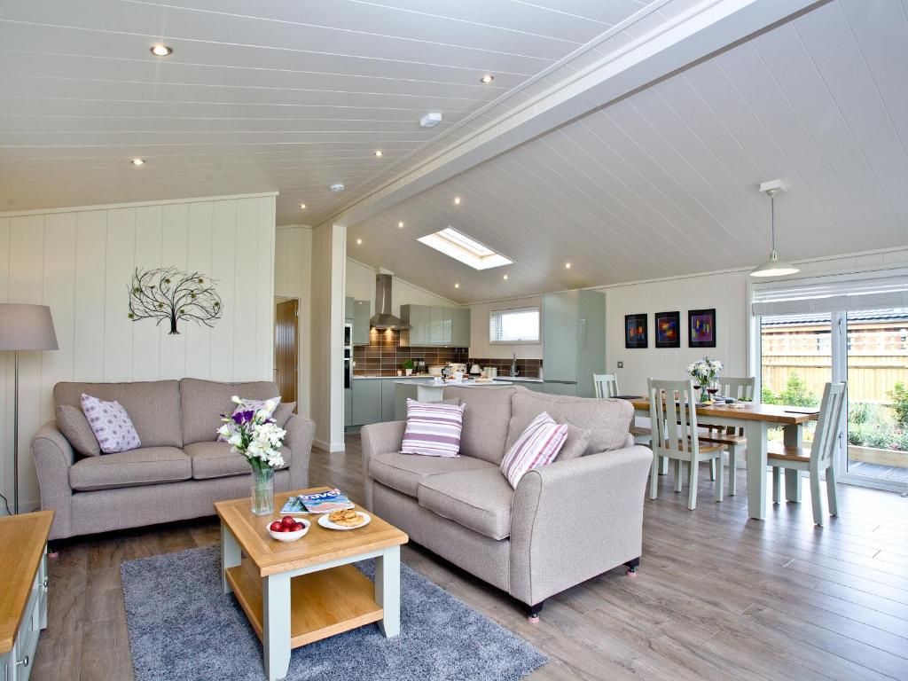 a living room with two couches and a table at Holly Lodge in Hassocks