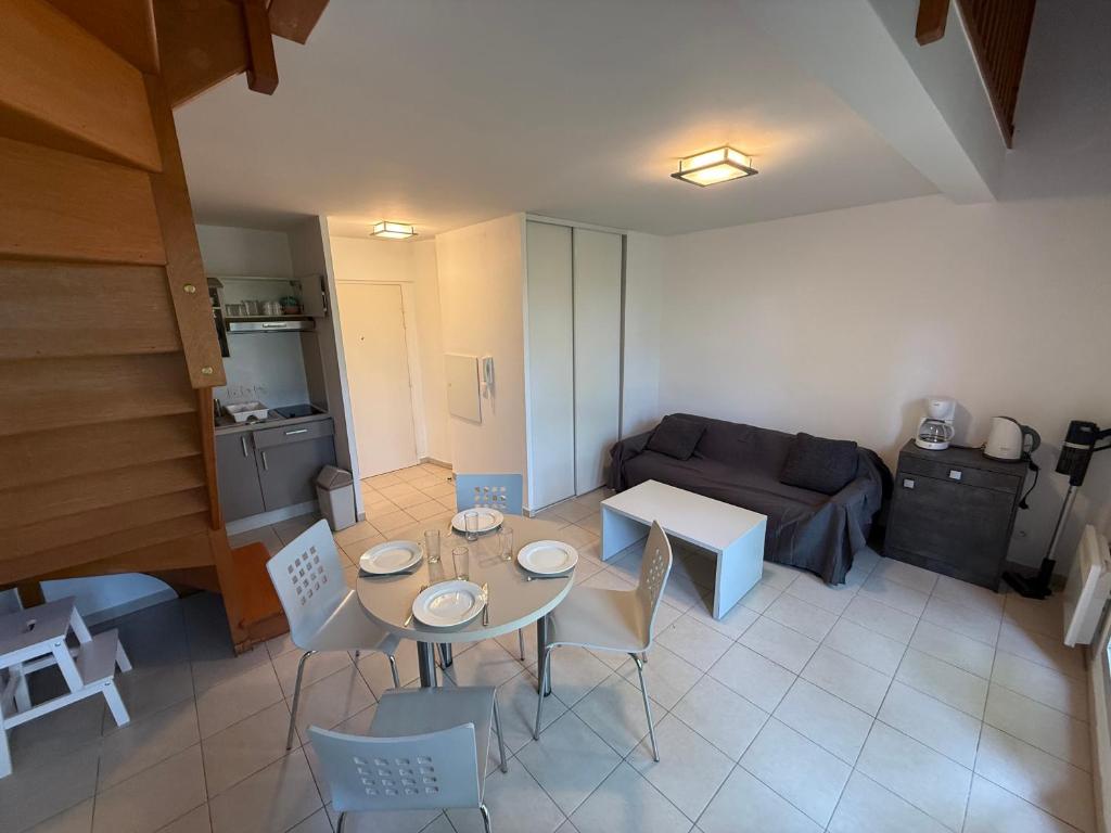 a living room with a table and a couch at Duplex Kedge Talence in Talence