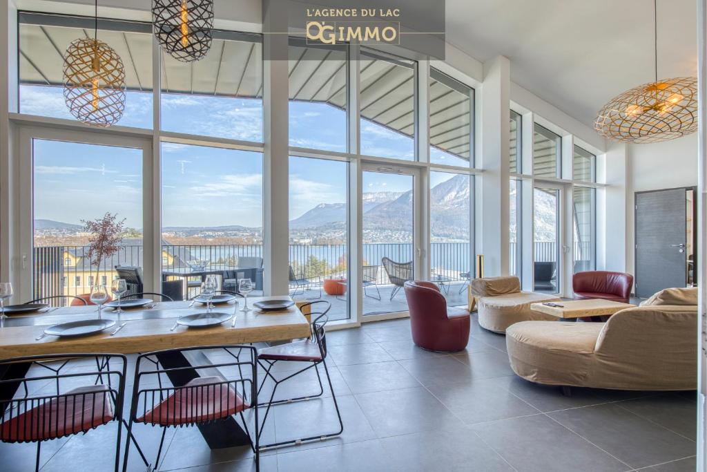 a living room with a table and a large window at Le Saphir - Vue panoramique sur le lac d'Annecy in Annecy