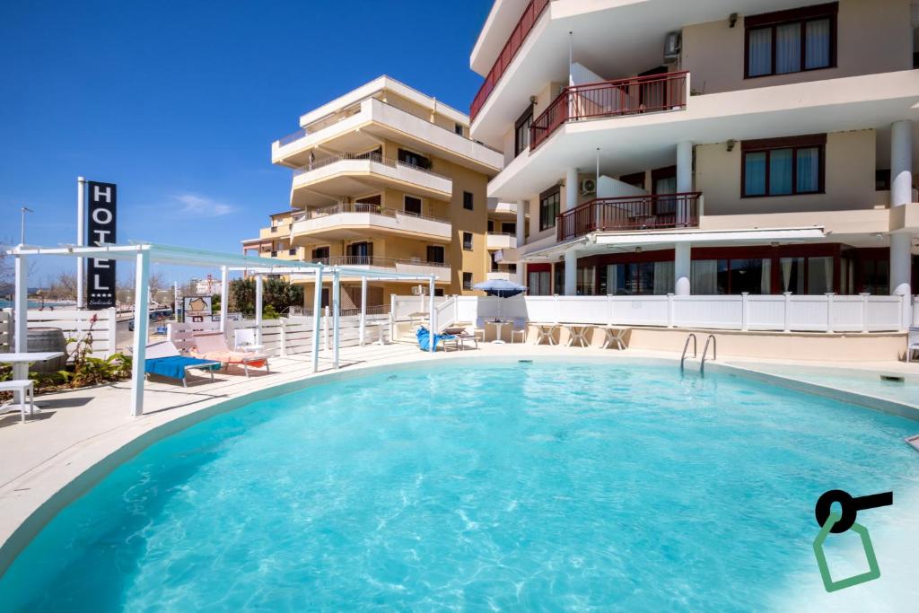 a swimming pool in front of a building at Hotiday Alghero Spiaggia in Alghero