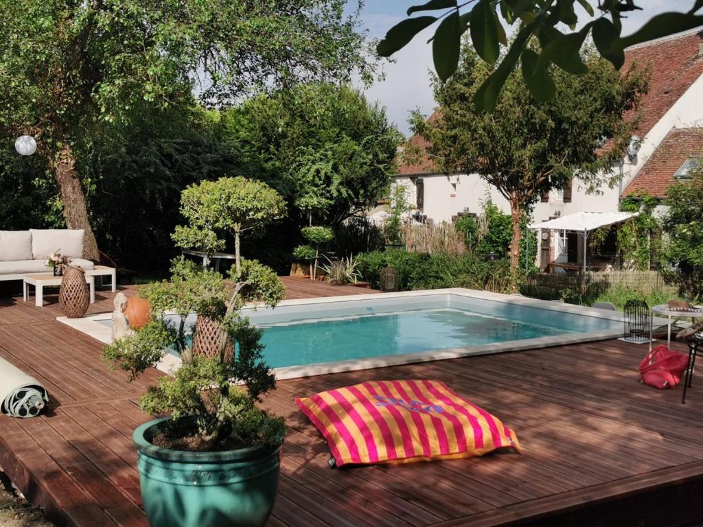 a swimming pool in a backyard with a wooden deck at La longère du Ruet in Saint-Hilaire-Saint-Mesmin