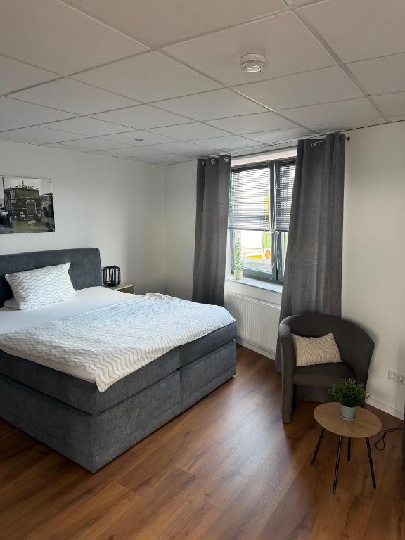 a bedroom with a bed and a chair and a window at Truck Inn in Bünde