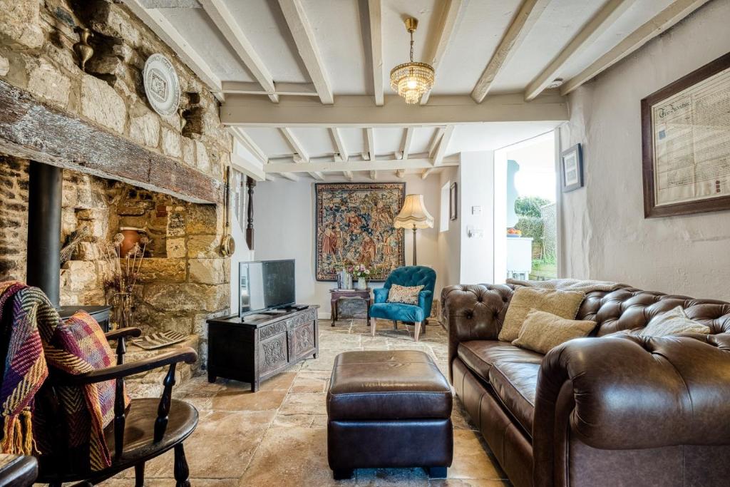 a living room with a couch and a stone wall at Pyatt's Pad in Winchcombe