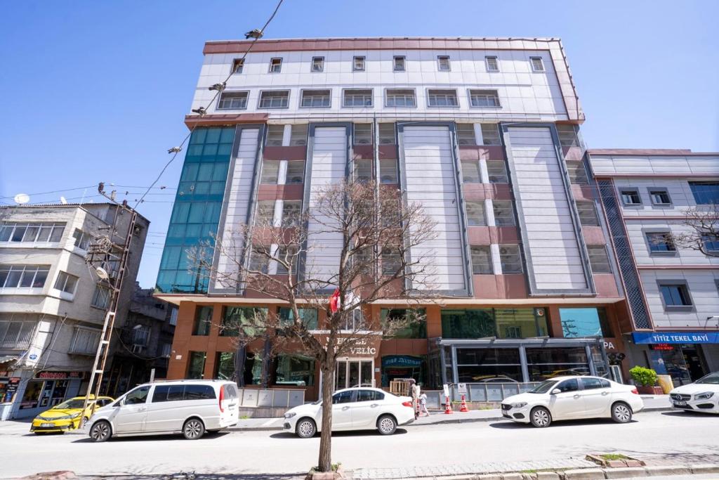 a tall building with cars parked in front of it at Buyuk Velic Hotel in Gaziantep