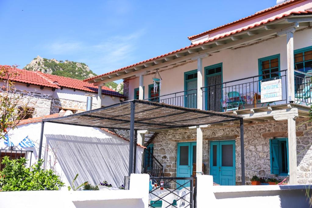 a stone building with blue doors and a balcony at House Marika - between Sea & mountains in Sykia Chalkidikis