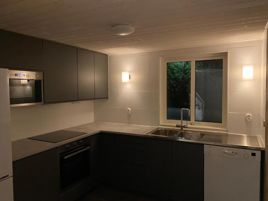 a kitchen with black cabinets and a sink and a window at Idyllic house in Timmernabben in Timmernabben