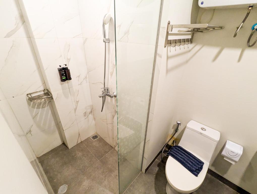 a bathroom with a toilet and a glass shower at Lovina 7-AA at One Residence in Batam Center