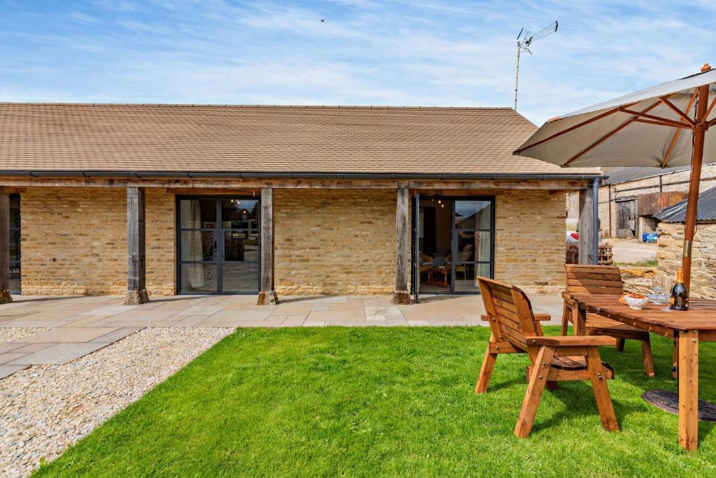 a patio with a table and chairs and an umbrella at Rabbit in Charlbury