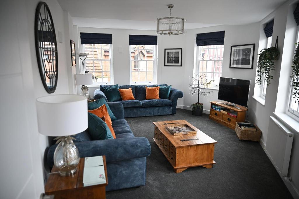 a living room with a blue couch and a coffee table at No 3 Central Chambers in Stratford-upon-Avon