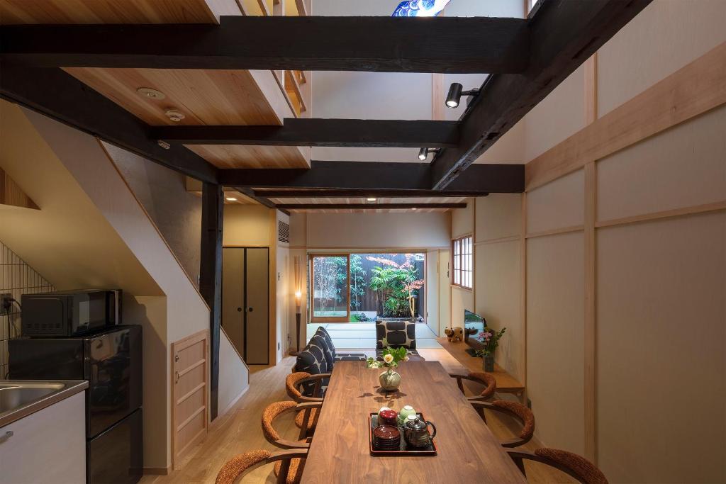 a dining room with a long wooden table and chairs at Shimabara Kaiden Machiya House in Kyoto