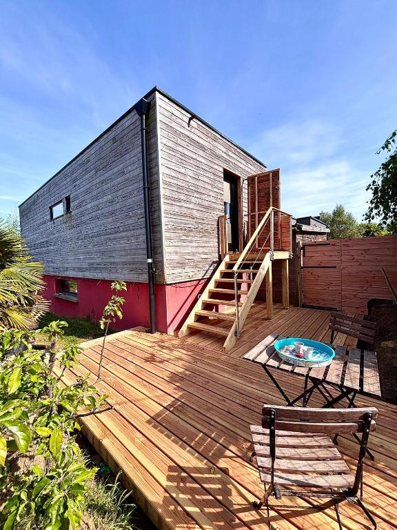 a house with a deck with a bench and a table at Le kesson in Saint-Brieuc