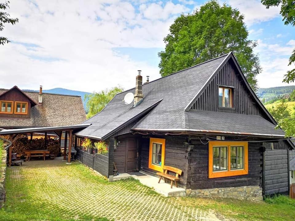 a home with a black roof and a patio at Chalupka pod Kozincom - Zázrivá in Zázrivá