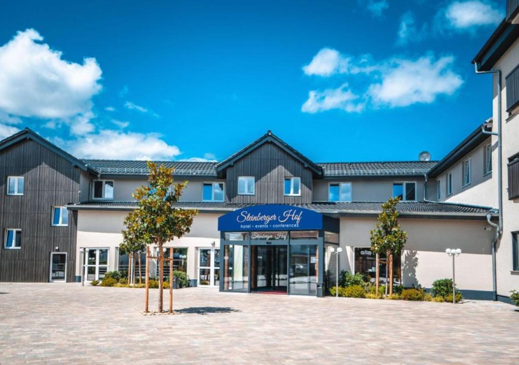 an exterior view of a building with a shopping center at Steinberger Hof in Dietzenbach
