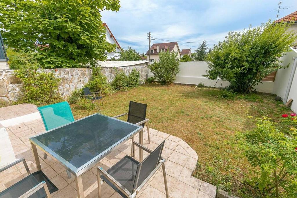 a patio with a table and chairs in a yard at La Montrachet in Dijon