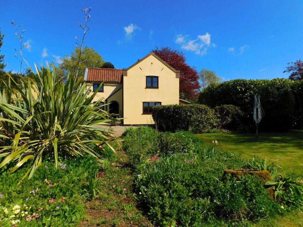 a house in the middle of a garden at Beechwood Cottage in Filby