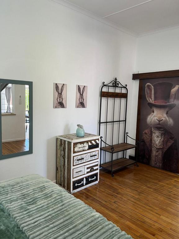 a bedroom with a bed and a painting of a cat in a top hat at Windpomp Guesthouse in Beaufort West