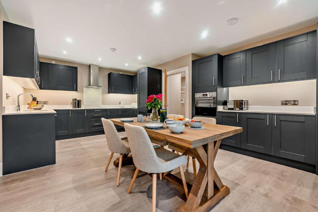 a large kitchen with a wooden table and chairs at Riverview in Burford