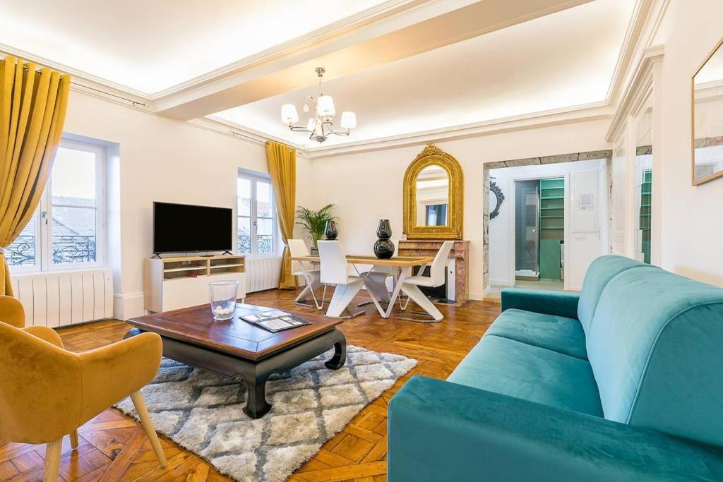 a living room with a blue couch and a table at Le Cote D'Or in Dijon