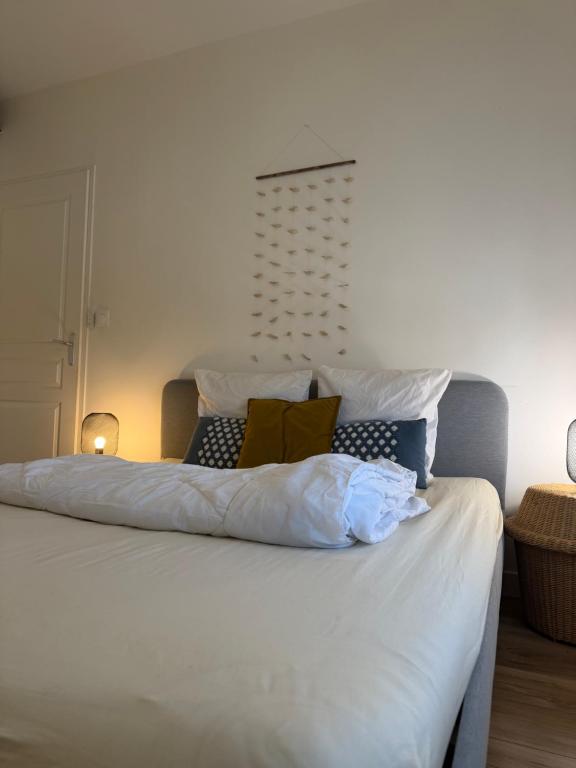 a bed with white sheets and pillows on it at Bosquet in Valence