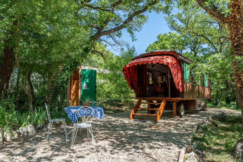 a tiny house on a trailer with a table and chairs at La Roulotte Authentique in Grignan
