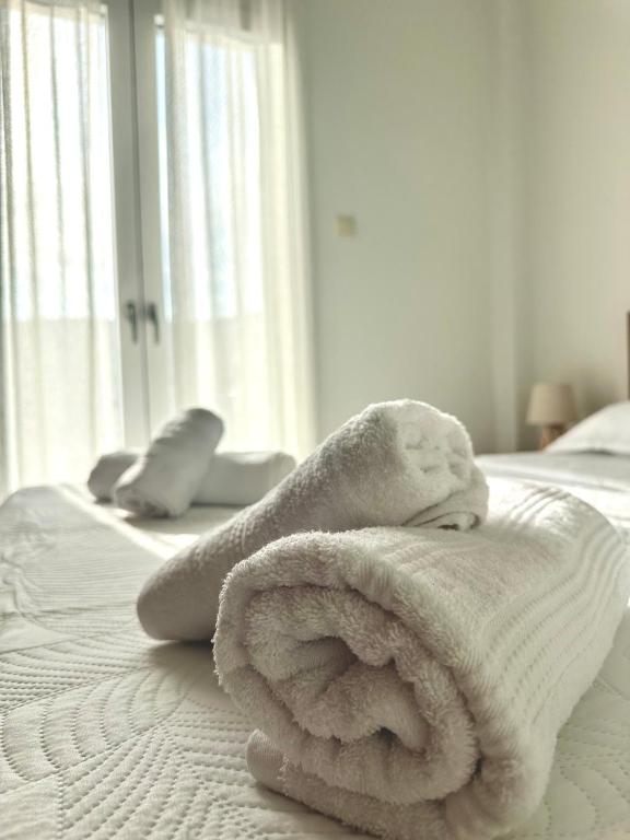 a white towel sitting on top of a bed at Arientas Apartment in Ermoupoli