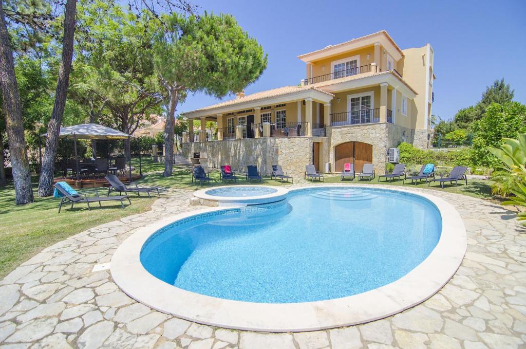 an image of a swimming pool in front of a house at Villa Lira by Algarve Holidays in Almancil