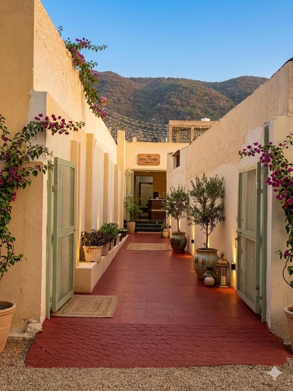 an alley with white buildings with plants and flowers at Hotel Star Inn , Pushkar in Pushkar