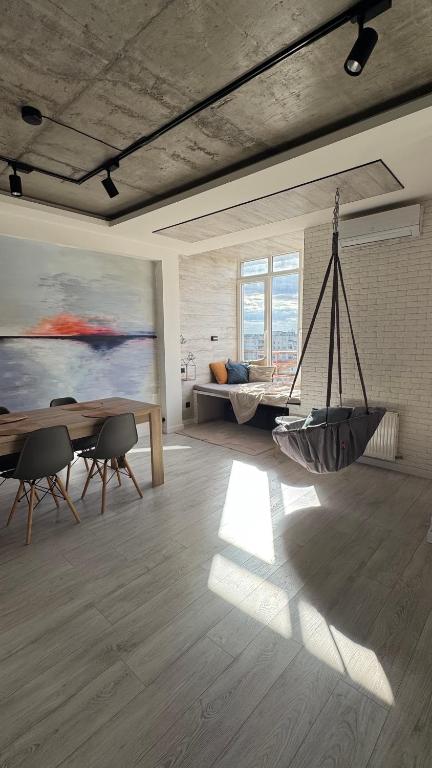 a living room with a hammock in the middle of a room at Spacious modern loft on Perfetskogo in Lviv