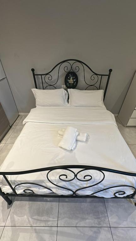 a bed with white sheets and two towels on it at Arcadia Hosting Aeroporto in Bologna