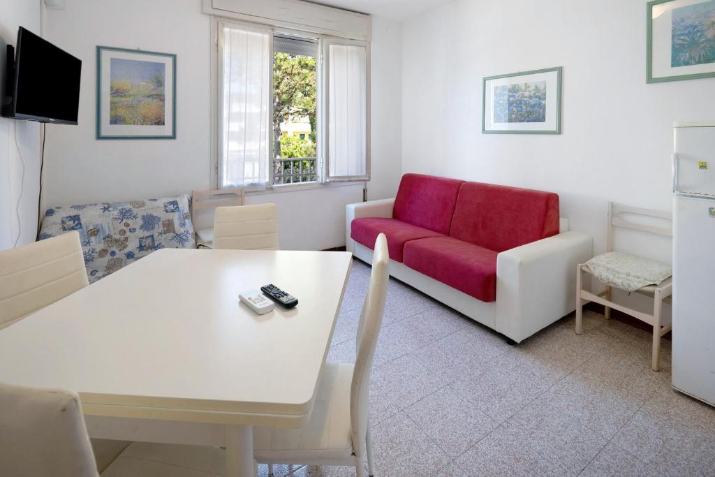 a living room with a table and a red couch at Erikbeach Bilo in Bibione