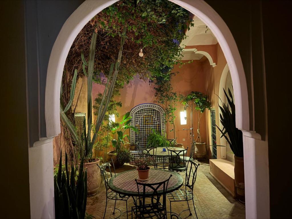 an archway with tables and chairs in a room with plants at Riad Medina Taroudant in Taroudant