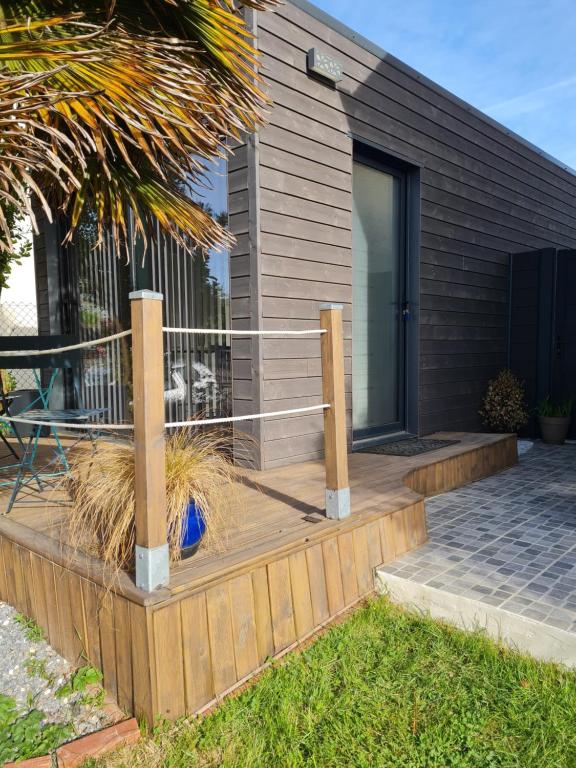 a house with a wooden deck with a fence at Guest House in Gévezé