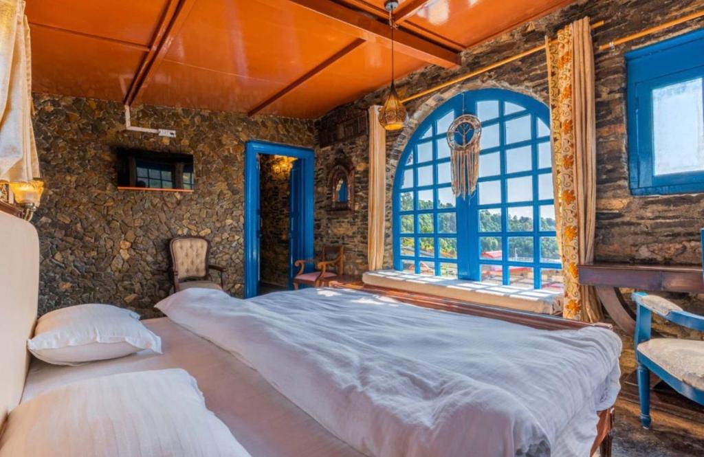 a bedroom with a large bed and a window at The Boho Mukteshwar in Mukteshwar