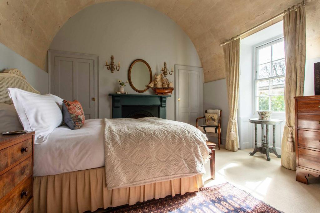 a bedroom with a bed and a fireplace and a window at Grand Georgian Residence in Bath