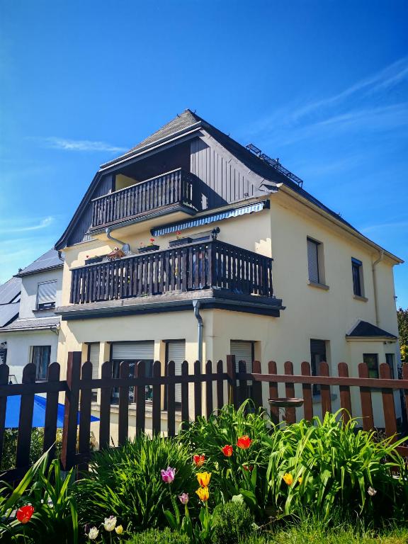 a white house with a fence and flowers at Ferienwohnung Richter in Pirna