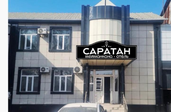 a building with a sign for a car repair shop at Саратан отель in Osh