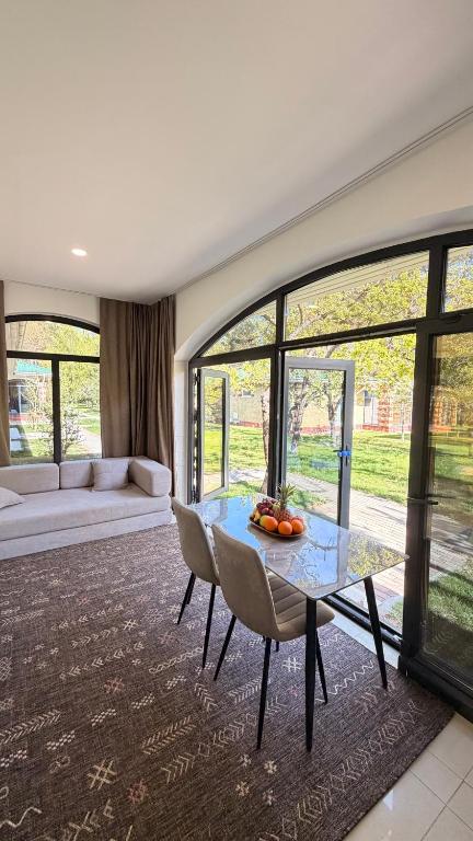 a living room with a glass table and chairs at Raduga Resort Orion in Chon-Sary-Oy