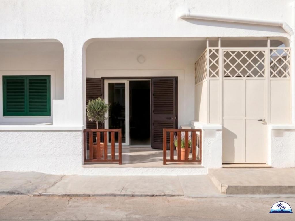 a white house with a gate and a door at La Mozza 739 in Torre San Giovanni Ugento