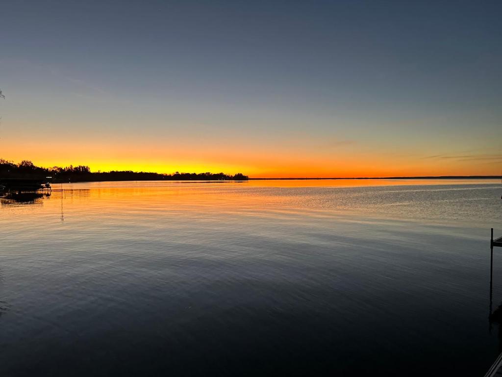 a sunset over a large body of water at Lake Drive apartment in Georgina