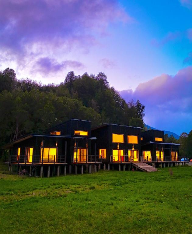 a house in a field with the lights on at Hotel Neyün La Junta in La Junta