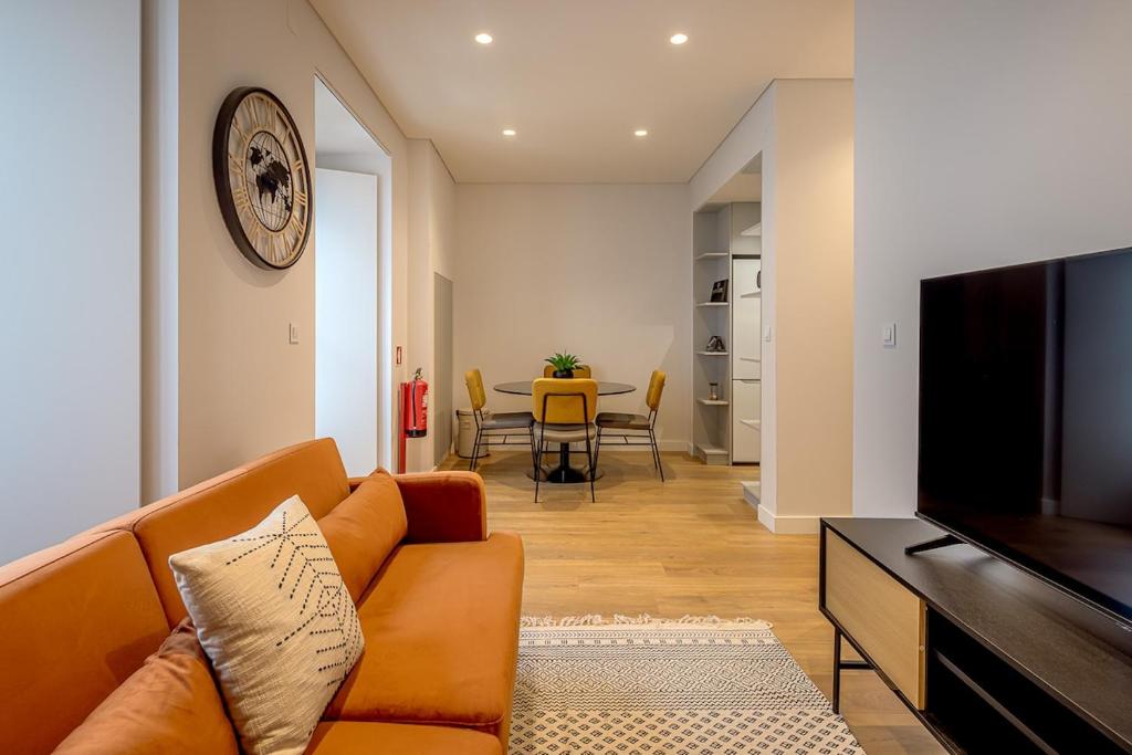 a living room with a couch and a flat screen tv at Glasgow Industrial 2BR apartment in Caparica