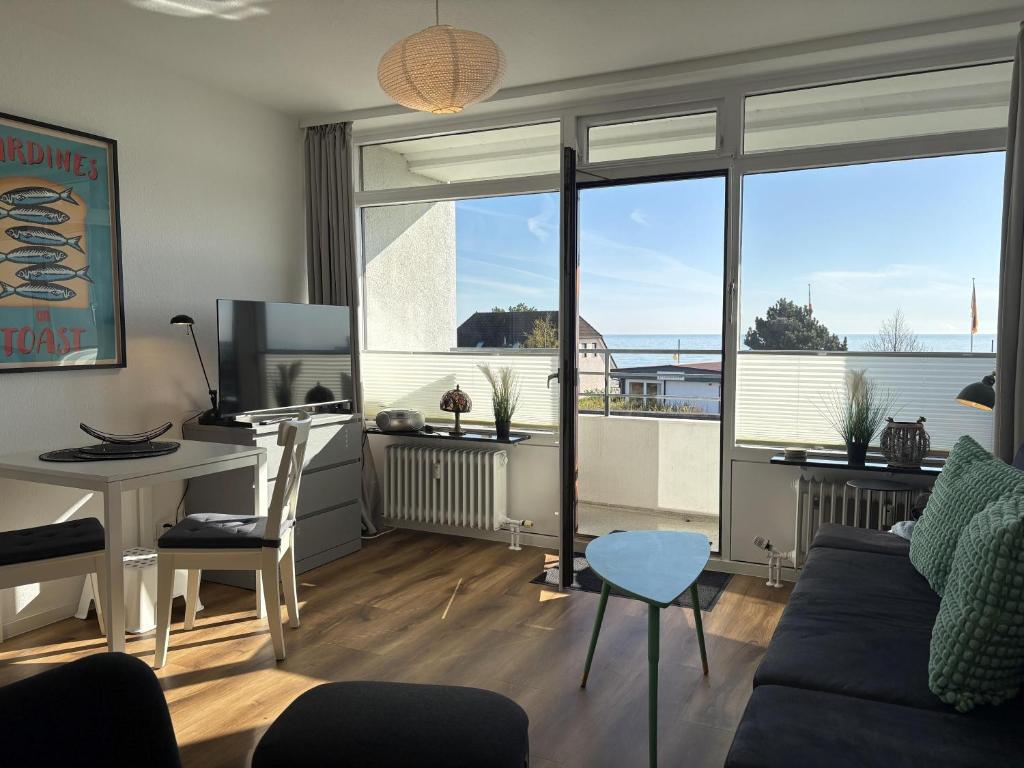 a living room with a couch and a desk with a computer at Strandhotel - 19 "Sardinenbüchse" in Dahme