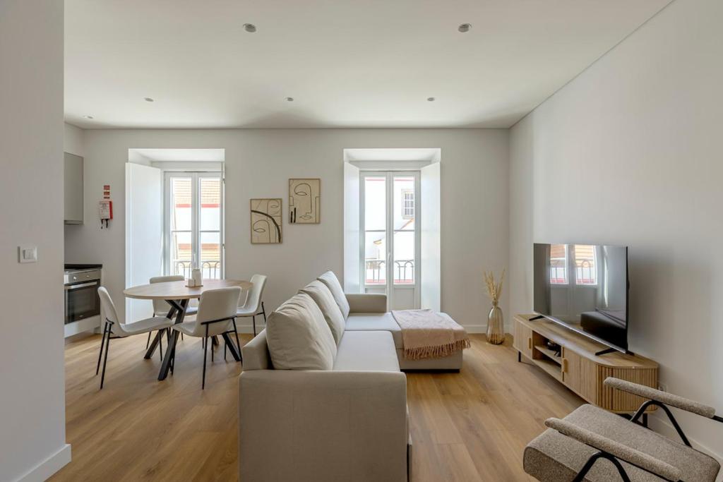 a living room with a couch and a table at Vienna 1BR Calm & Cozy Escape in Caparica