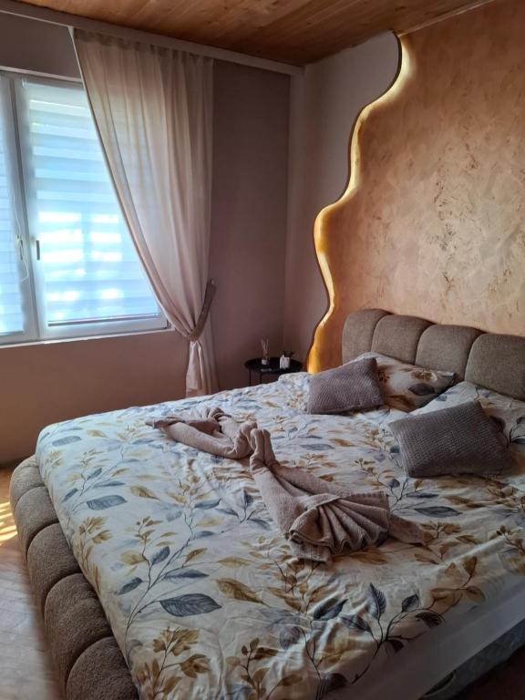 a woman laying on a bed in a bedroom at NeNa Apartmani - Ruma #2 in Ruma