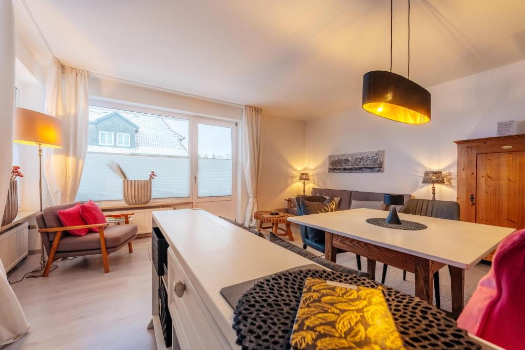 a living room with a large window and a table at Halali Braunlage in Braunlage
