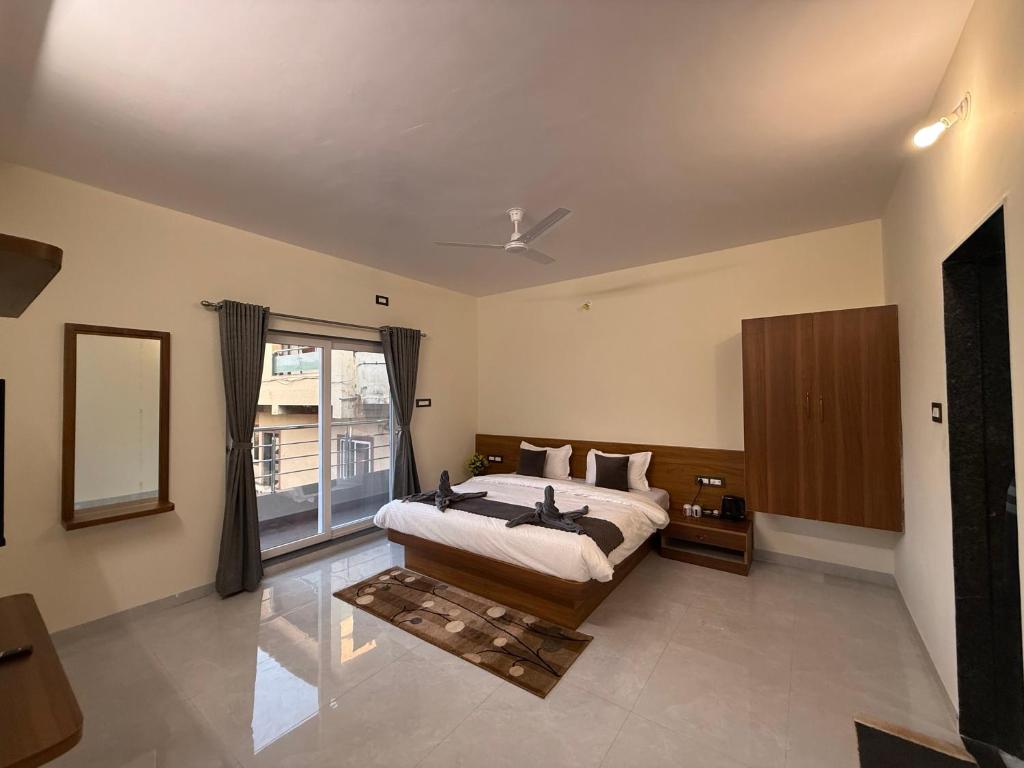 a bedroom with a bed and a large window at Shreya Bungalow Mahabaleshwar in Mahabaleshwar
