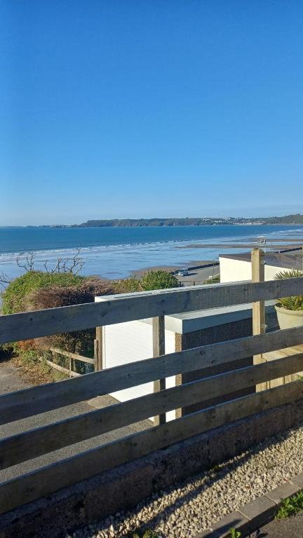 a wooden fence with a view of the water at Waters edge in Amroth