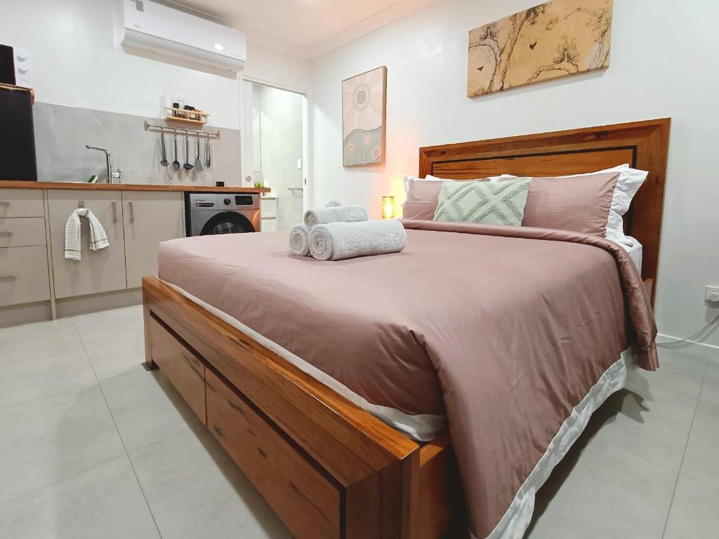 a bedroom with a large bed with towels on it at Executive Studio - Private Parking in Holmview